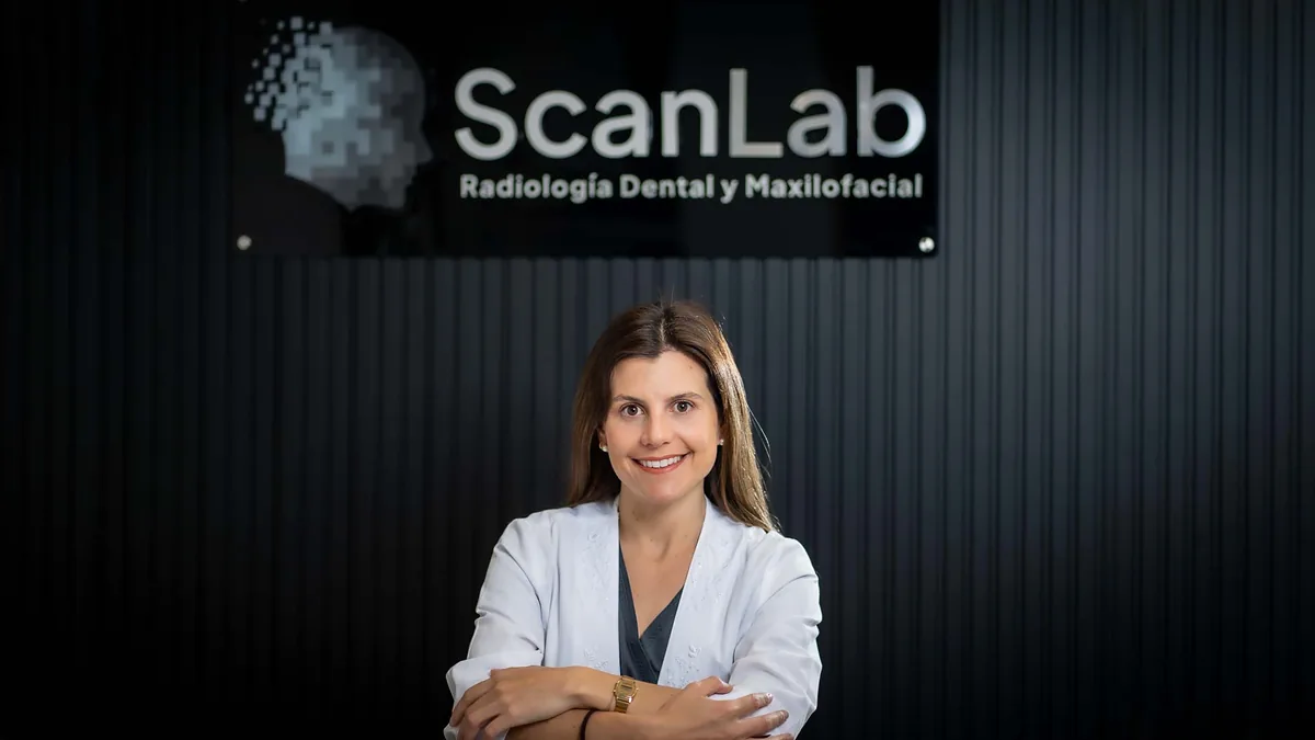 Profesional radióloga de ScanLab frente al letrero de la clínica